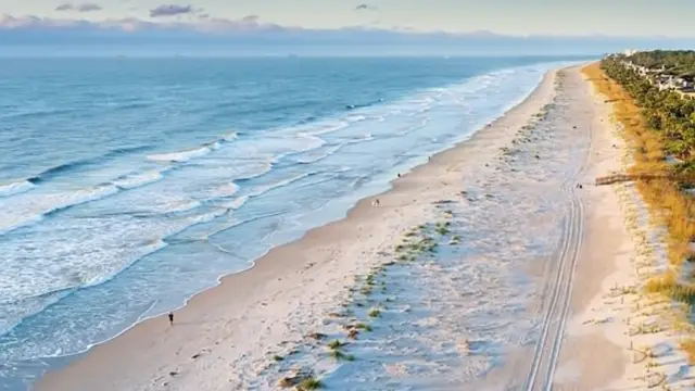 Hilton Head Island from the air: the beach, a dune boardwalk, a jet ski and a parasail at sunset, and sea oats